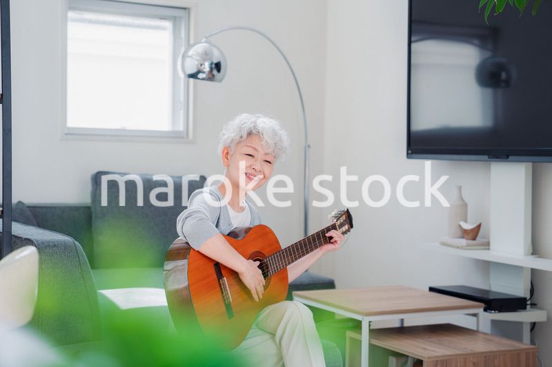 ギターを演奏するシニアの女性