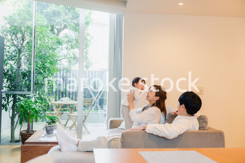 赤ちゃんと高い高いをして遊ぶファミリー