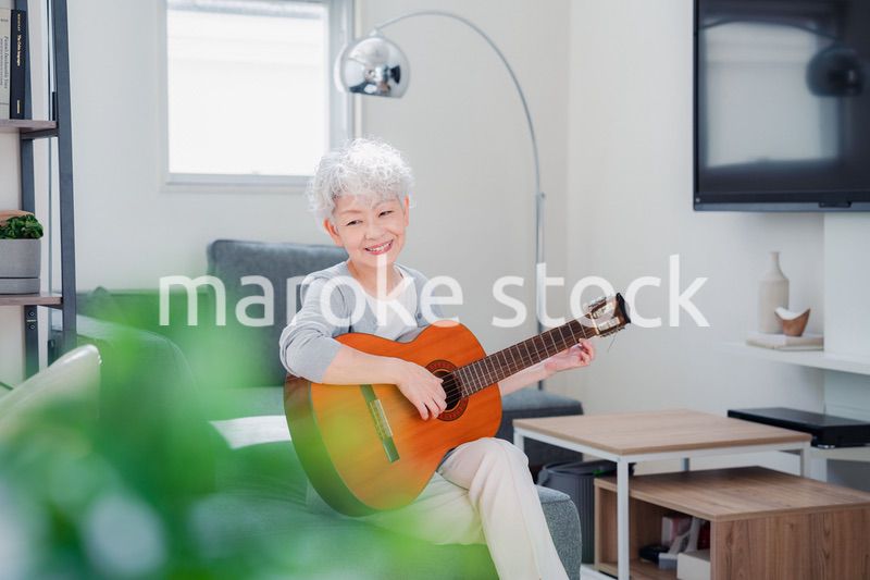 ギターを演奏するシニアの女性