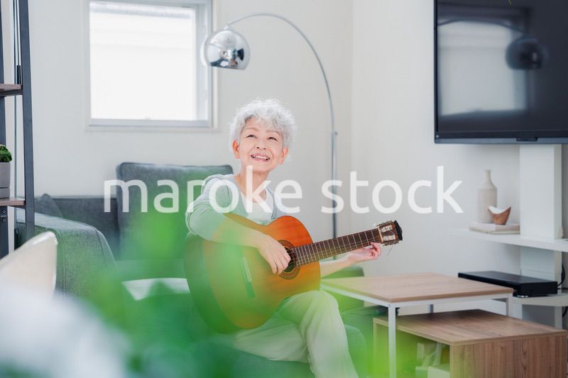 ギターを演奏するシニアの女性