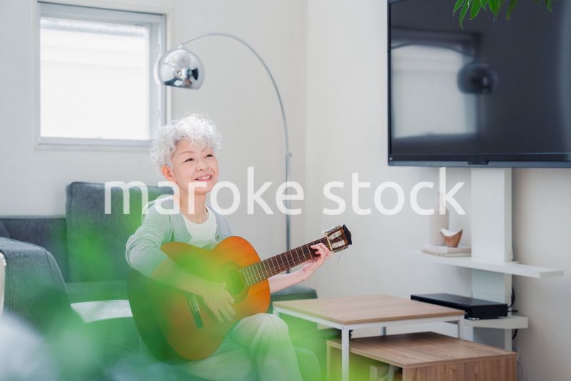 ギターを演奏するシニアの女性