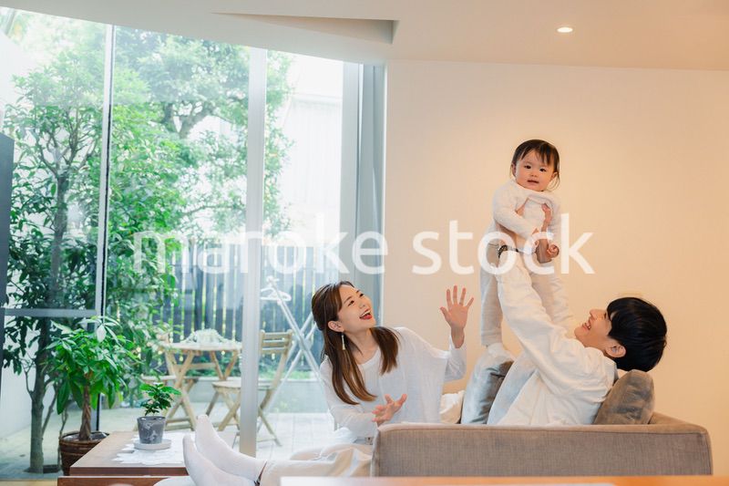 赤ちゃんと高い高いをして遊ぶファミリー