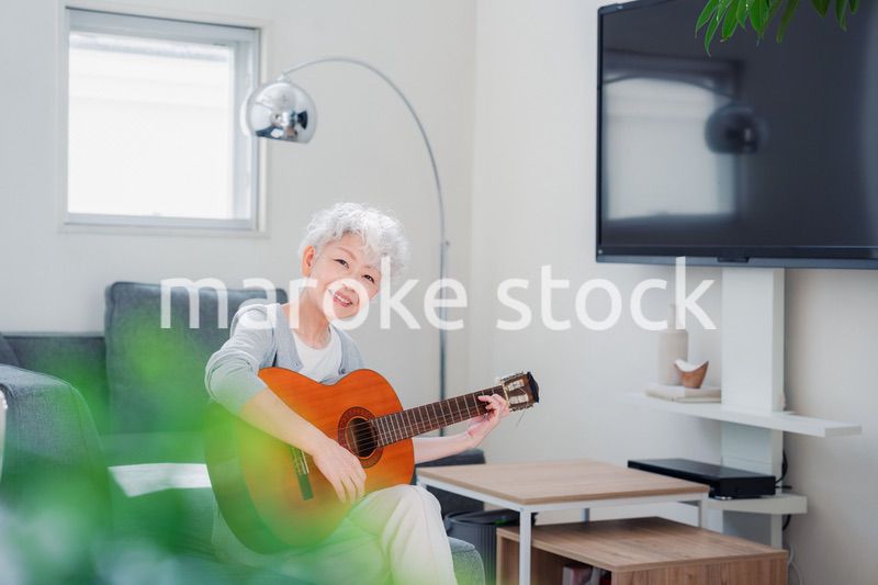 ギターを演奏するシニアの女性