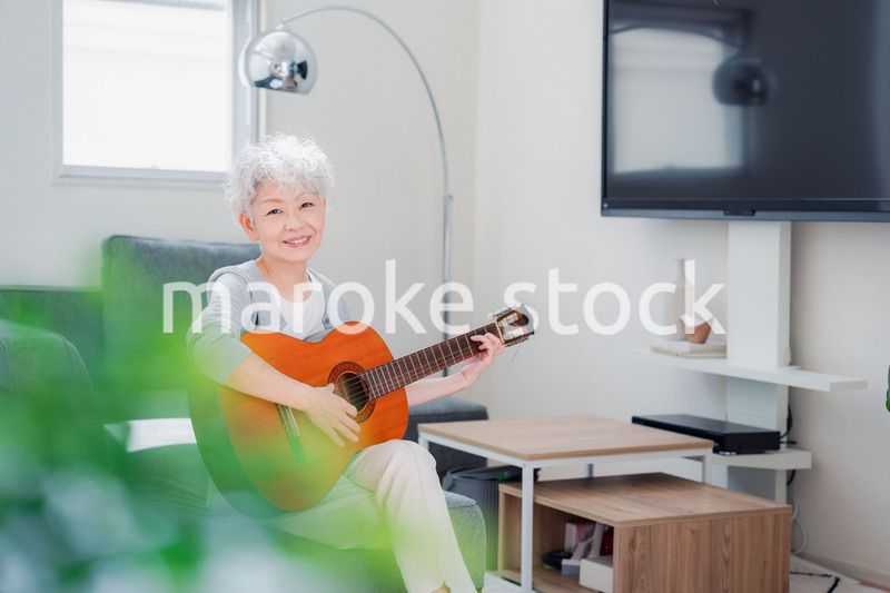 ギターを演奏するシニアの女性