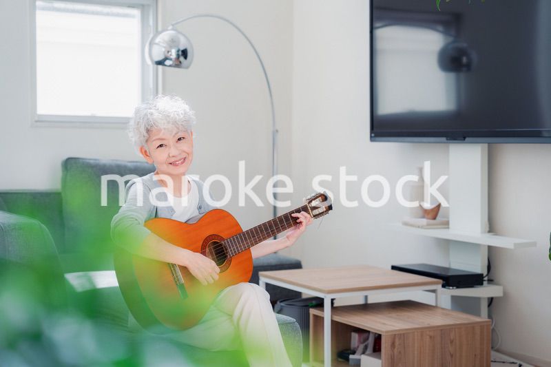 ギターを演奏するシニアの女性