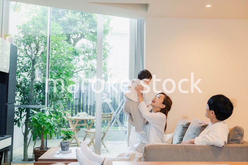 赤ちゃんと高い高いをして遊ぶファミリー