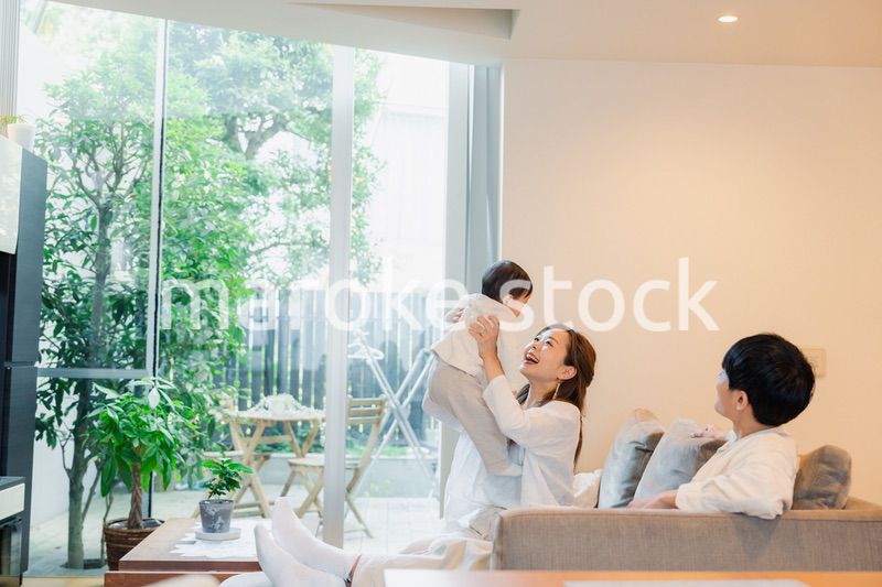 赤ちゃんと高い高いをして遊ぶファミリー