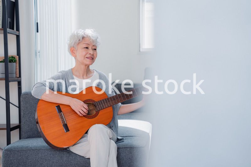 ギターを演奏するシニアの女性