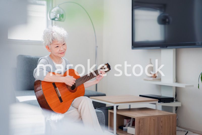 ギターを演奏するシニアの女性