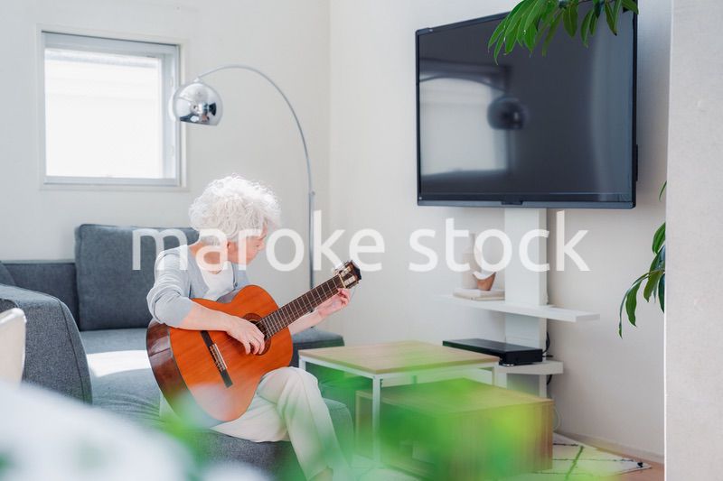 ギターを演奏するシニアの女性