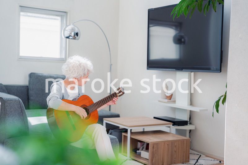 ギターを演奏するシニアの女性