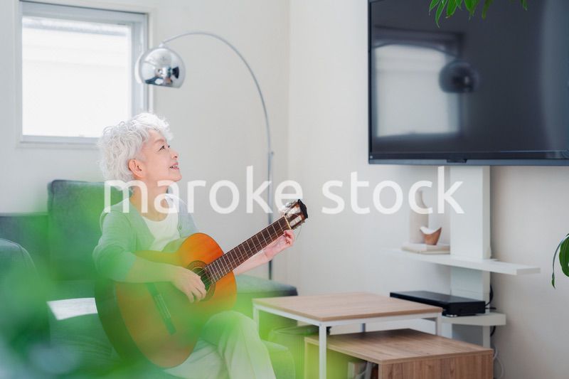 ギターを演奏するシニアの女性