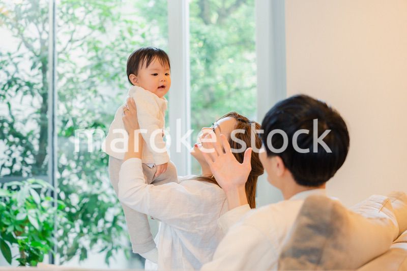 赤ちゃんと高い高いをして遊ぶファミリー