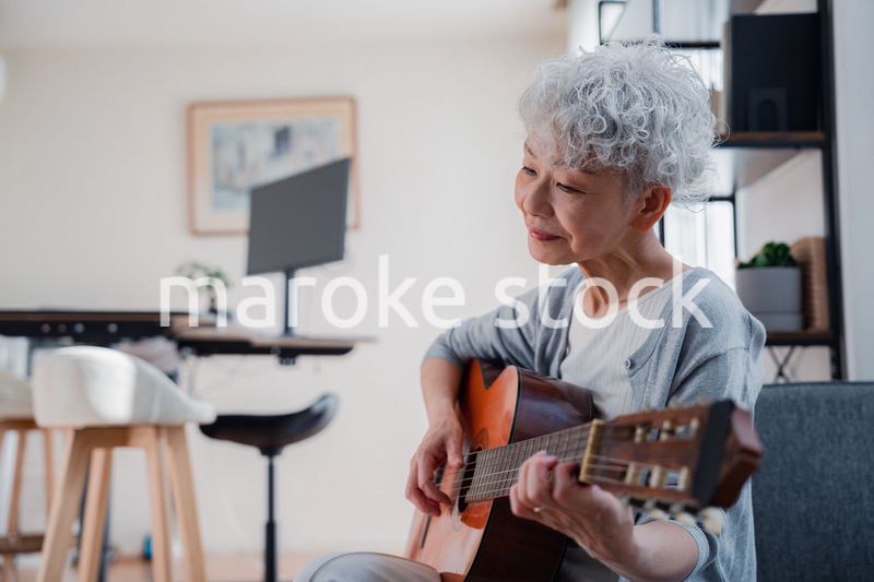 ギターを演奏するシニアの女性