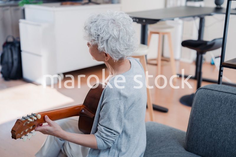 ギターを演奏するシニアの女性