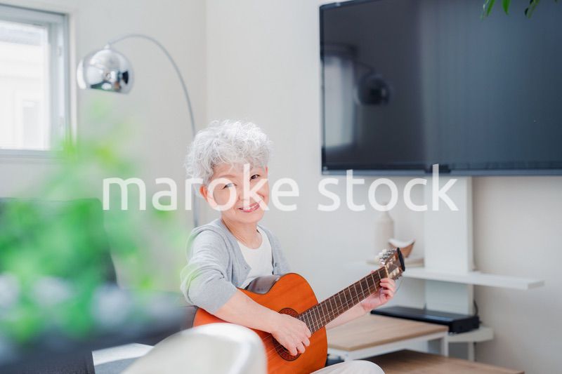 ギターを演奏するシニアの女性