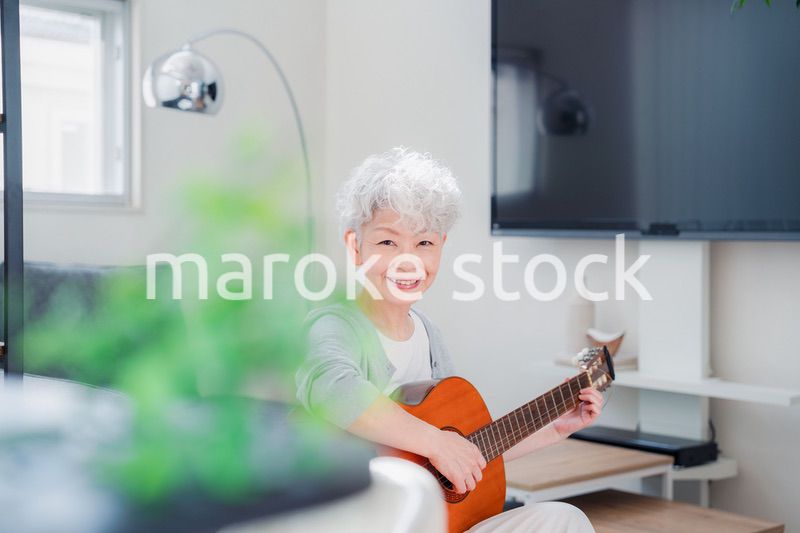 ギターを演奏するシニアの女性