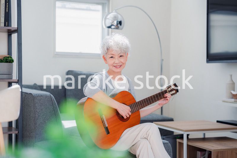 ギターを演奏するシニアの女性