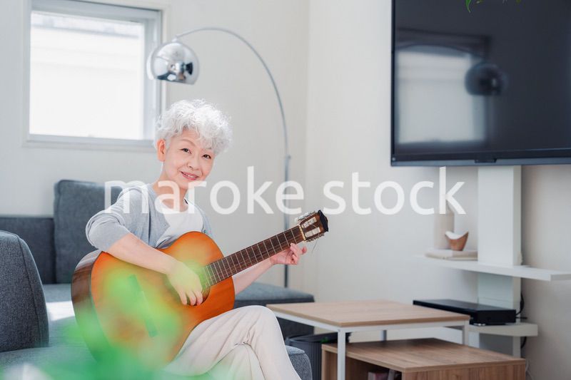 ギターを演奏するシニアの女性