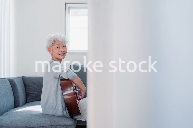 ギターを演奏するシニアの女性