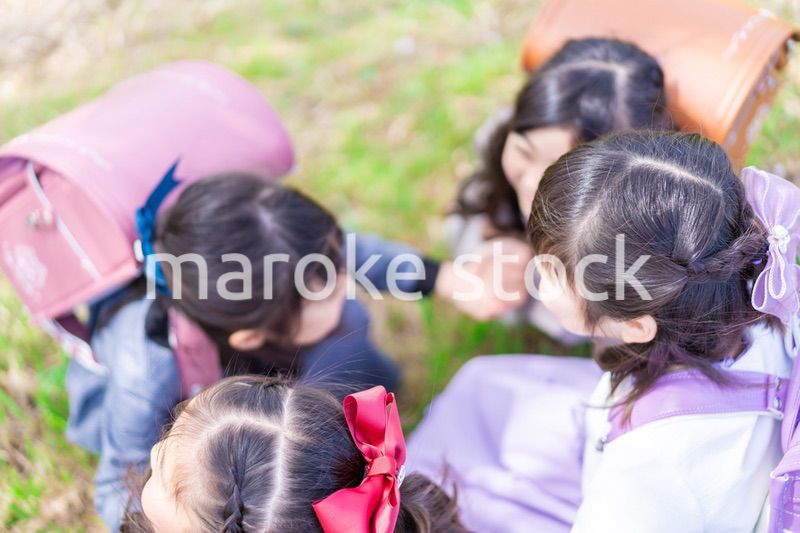 登下校中に通学路で遊ぶ小学生の女の子たち