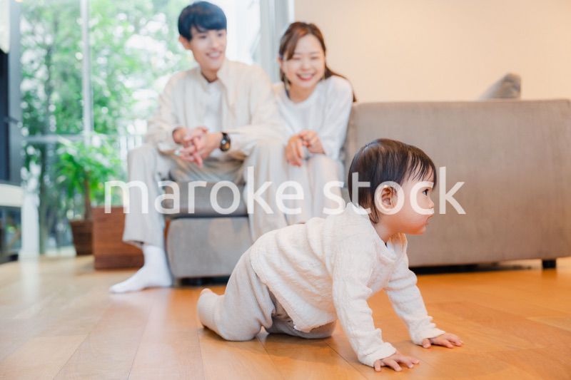 ハイハイをする赤ちゃんと子供の成長を見守る両親