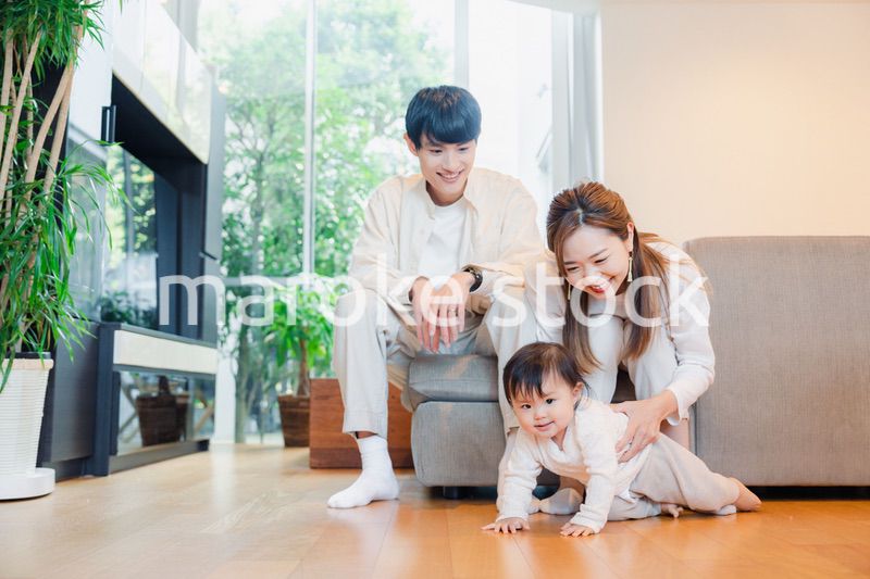 ハイハイをする赤ちゃんと子供の成長を見守る両親