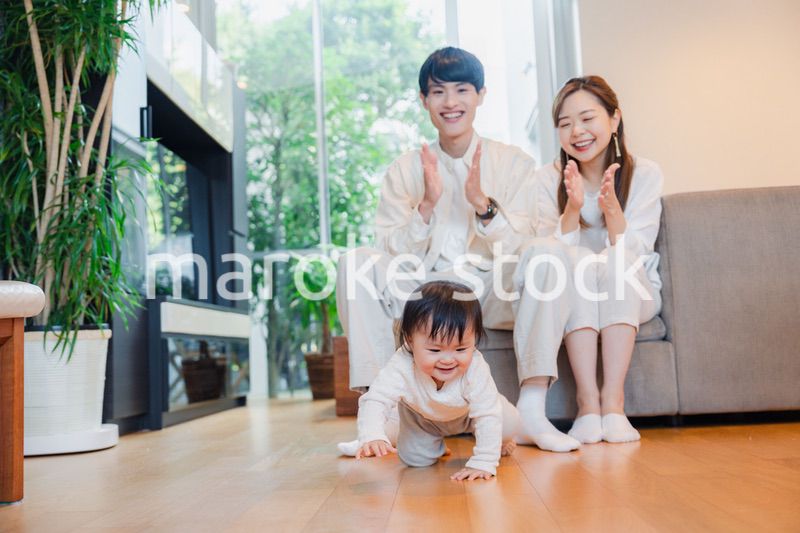 ハイハイをする赤ちゃんと子供の成長を見守る両親