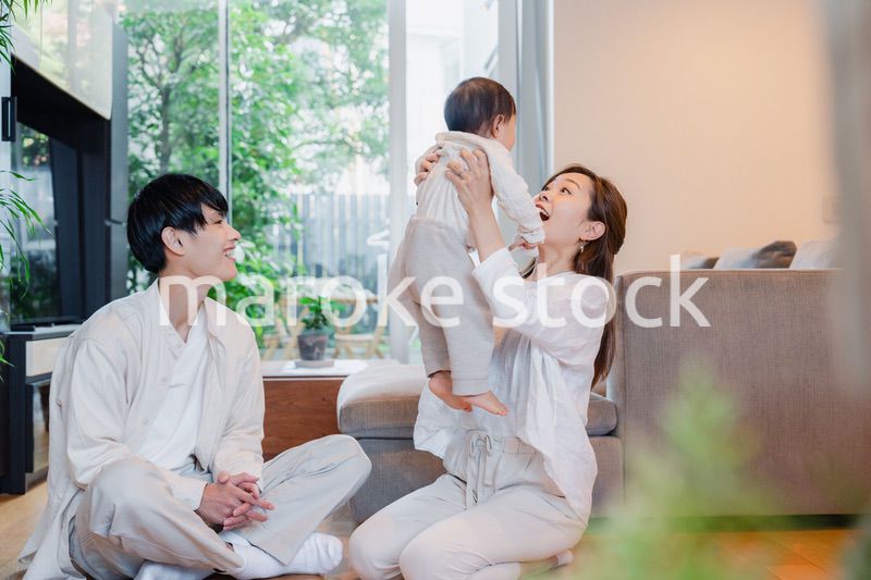 赤ちゃんと高い高いをして遊ぶファミリー