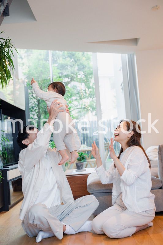 赤ちゃんと高い高いをして遊ぶファミリー