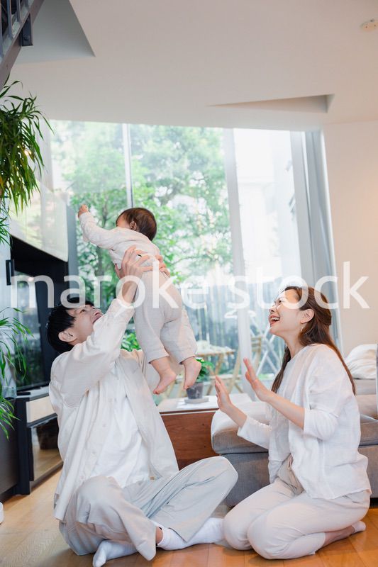 赤ちゃんと高い高いをして遊ぶファミリー