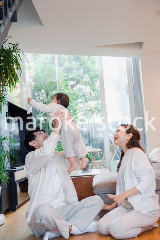 赤ちゃんと高い高いをして遊ぶファミリー