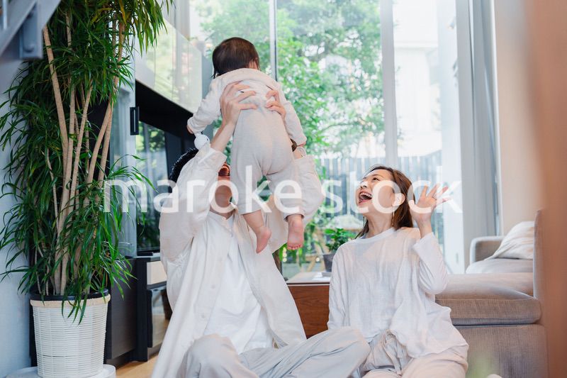 赤ちゃんと高い高いをして遊ぶファミリー