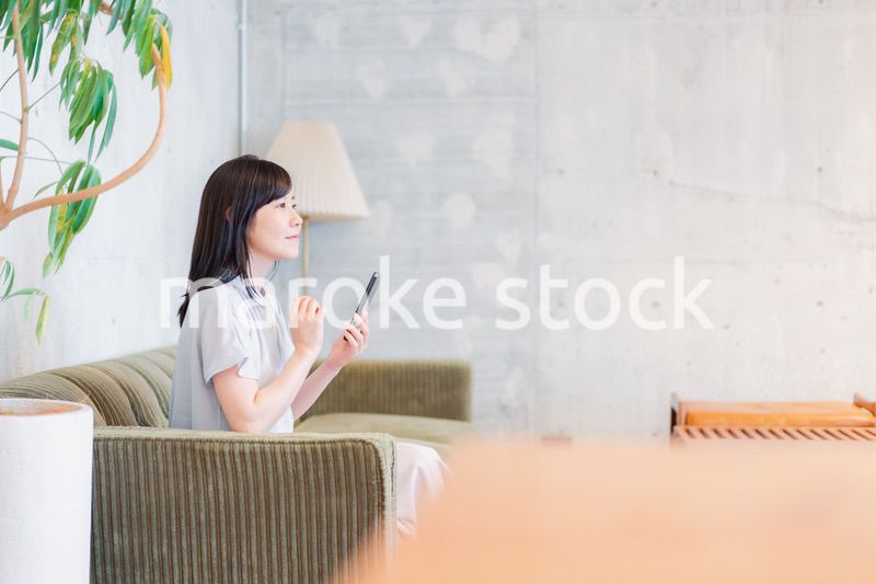 ラウンジでスマホを使うビジネスウーマン