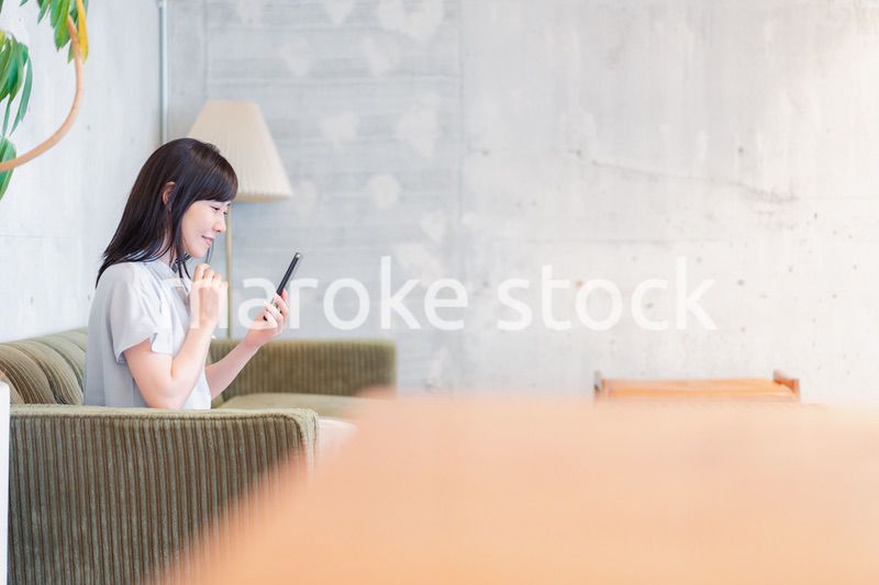 ラウンジでスマホを使うビジネスウーマン