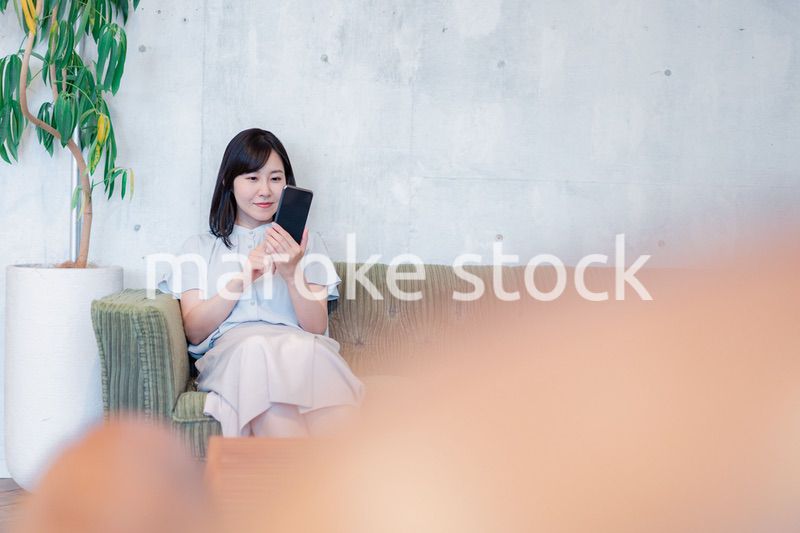 ラウンジでスマホを使うビジネスウーマン