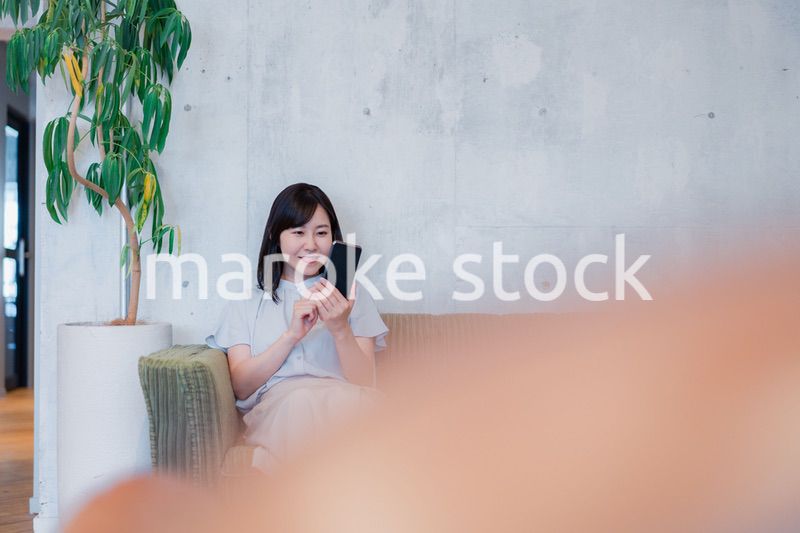 ラウンジでスマホを使うビジネスウーマン