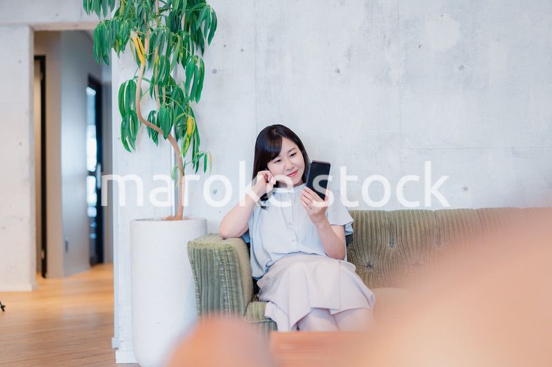 ラウンジでスマホを使うビジネスウーマン