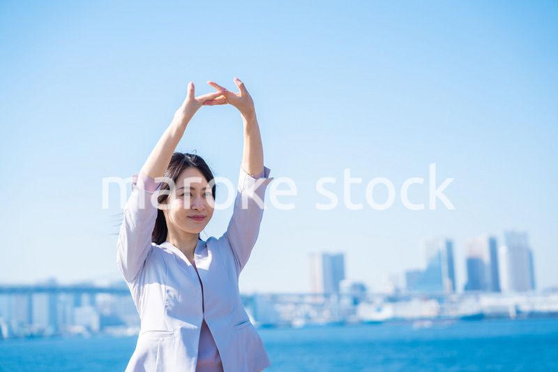 外で深呼吸をする若いビジネスウーマン