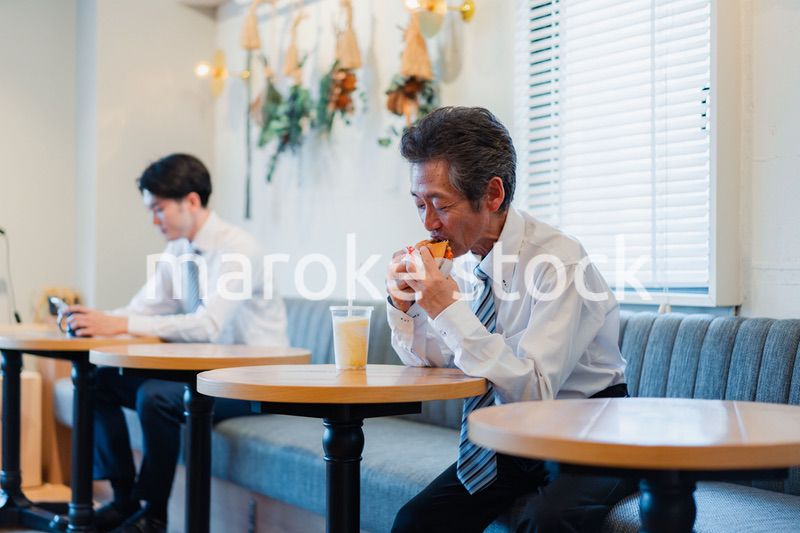 ハンバーガーショップでランチを食べるビジネスマン