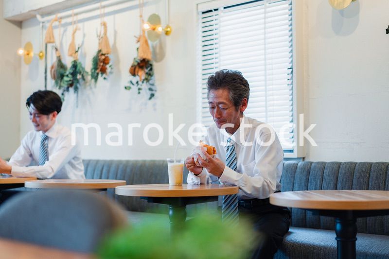 ハンバーガーショップでランチを食べるビジネスマン