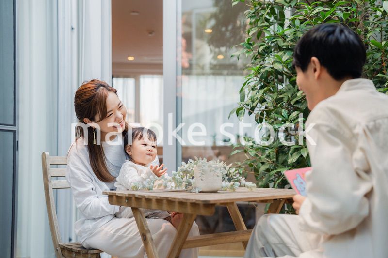 おうちのテラスで赤ちゃんと過ごす家族