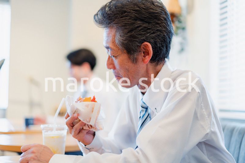 ハンバーガーショップでランチを食べるビジネスマン