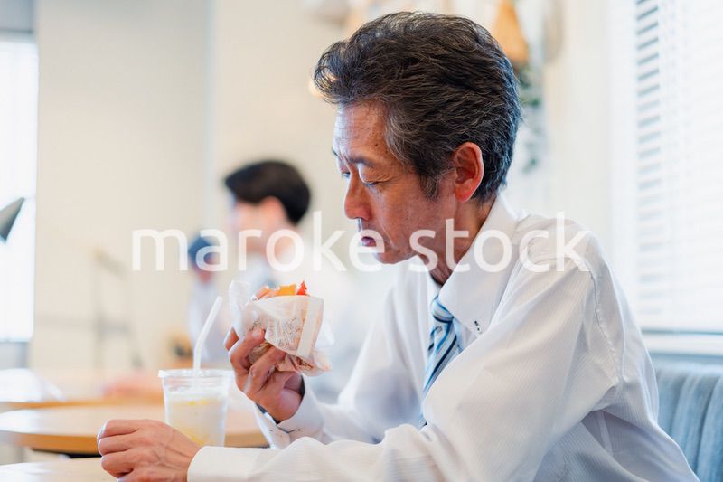 ハンバーガーショップでランチを食べるビジネスマン