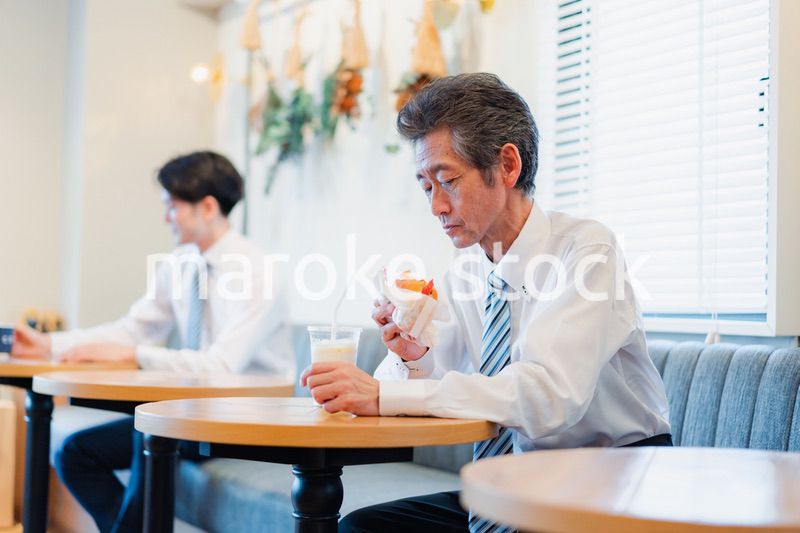 ハンバーガーショップでランチを食べるビジネスマン