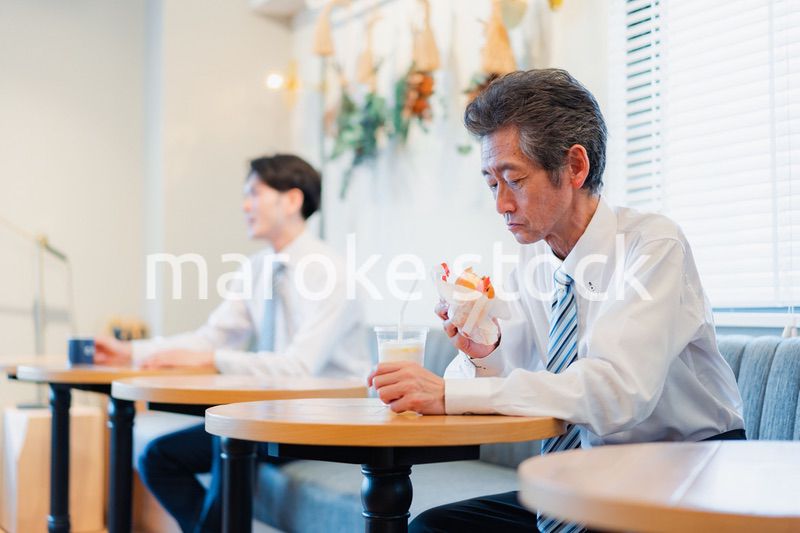 ハンバーガーショップでランチを食べるビジネスマン