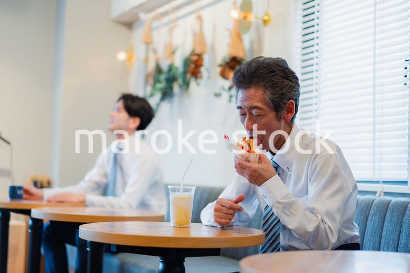 ハンバーガーショップでランチを食べるビジネスマン