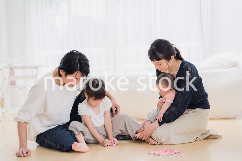 お家で折り紙遊びをする家族