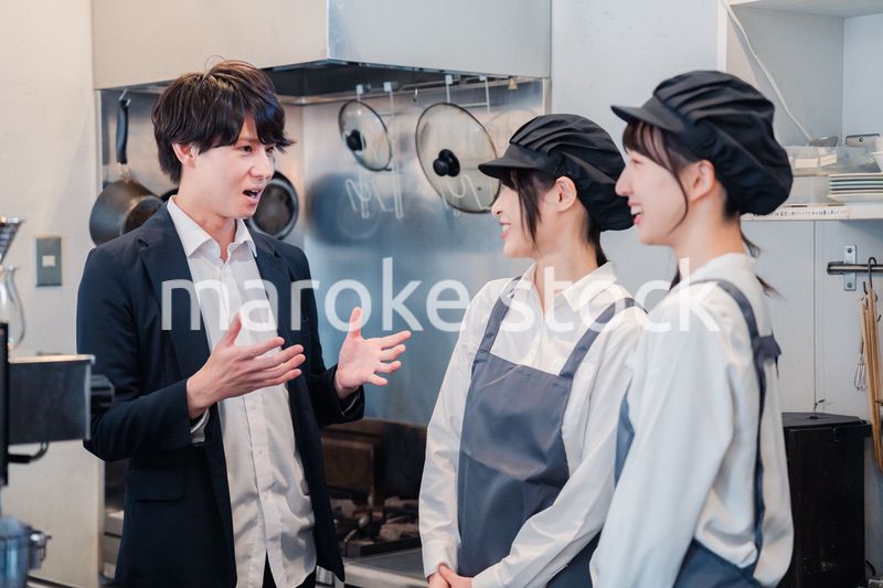 レストランのオーナーと話をするスタッフ