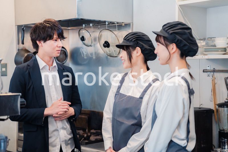 レストランのオーナーと話をするスタッフ